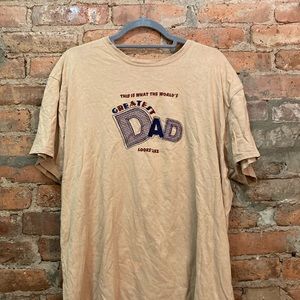 X-large tan t-shirt stating “this is what the worlds greatest dad looks like”